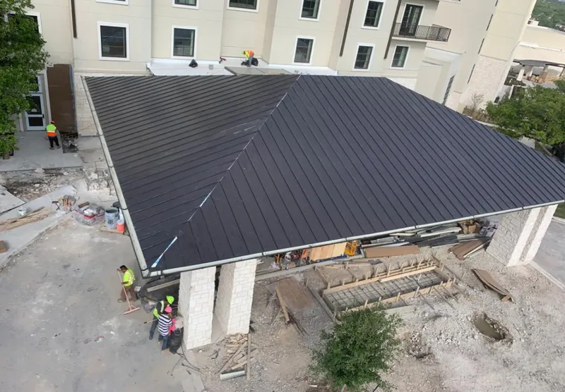 Metal roofing installation team working on a commercial building in Weston